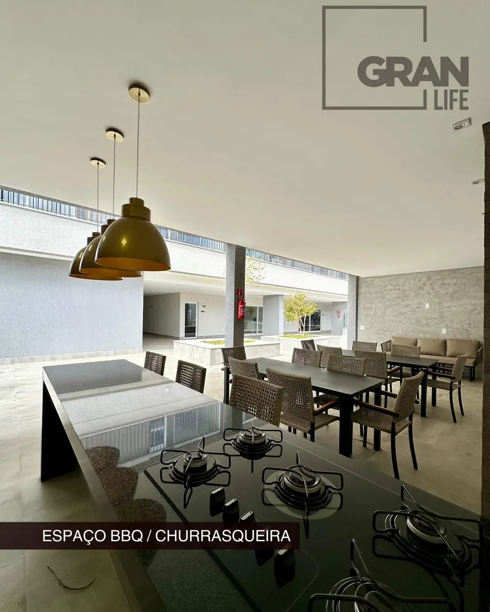 Ambiente de churrasqueira com mesas e área de convivência.